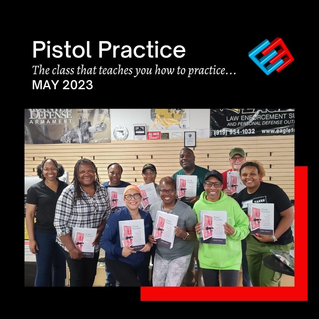 Classroom of nine men and women smiling at the camera while holding up their copies of Pistol Practice, with their instructor, Joy Allen, also present. The banner above reads 'May 2023: Pistol Practice: The class that teaches you how to practice.